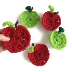 Puede incluir: Cinco pa&ntilde;os de cocina de ganchillo con forma de manzana, dos rojos y tres verdes, con una hoja y un tallo verdes en cada uno.