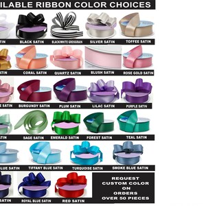 Op de afbeelding: Een tabel met 21 verschillende kleuren satijnen lint. De lintkleuren omvatten wit, zwart, zilver, goud, koraal, kwarts, blush, roosgoud, mauve roze, bordeauxrood, pruim, lila, paars, mint, salie, smaragd, bos, teal, lichtblauw, Tiffany blauw, turquoise, marineblauw, koninklijk blauw, rood en rookblauw. De tekst "REQUEST CUSTOM COLOR ON ORDERS OVER 50 PIECES" staat onderaan de tabel.