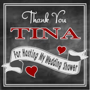 May include: A chalkboard sign with white lettering that says "Thank You TINA for Hosting My Wedding Shower". There are two red hearts on the sign.