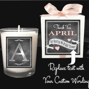 May include: A white gift box with a pink ribbon and a black chalkboard style label that says "Thank You APRIL For Hosting My Bridal Shower". A white candle with a black chalkboard style label that says "A" is next to the gift box.