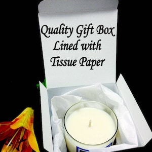 May include: A white gift box with the text "Quality Gift Box Lined with Tissue Paper" printed on the inside of the lid. The box is open and contains a white candle in a clear glass jar.