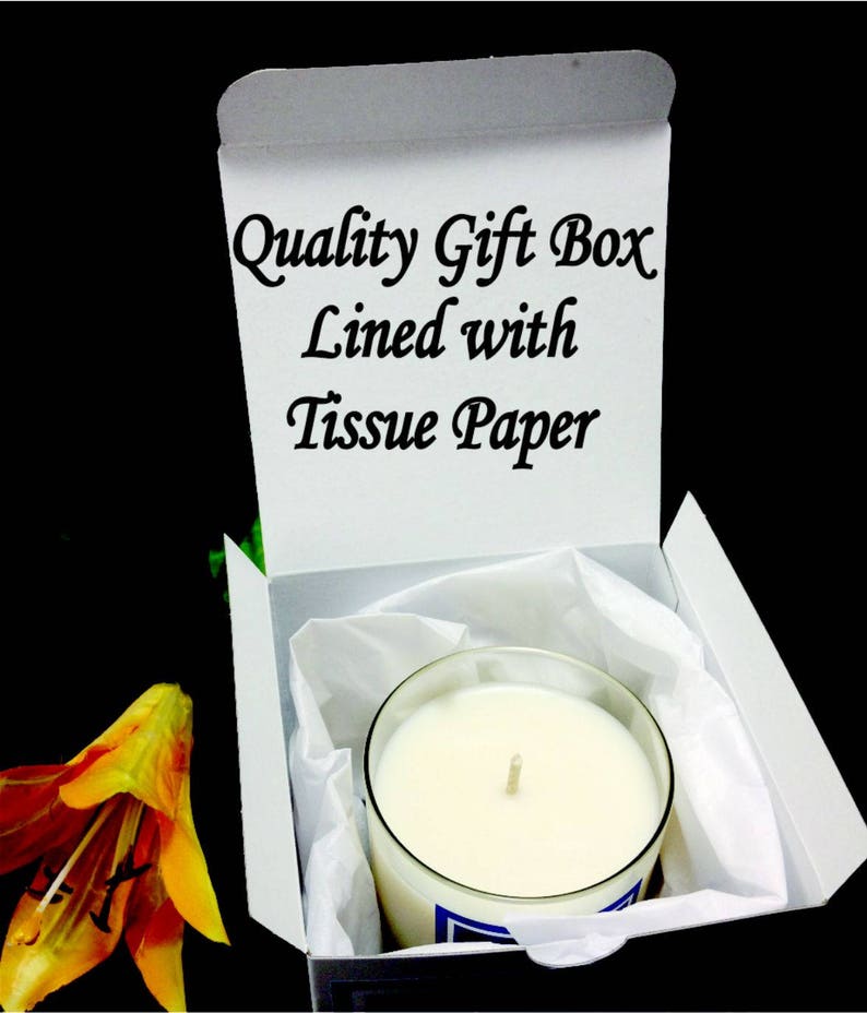May include: A white gift box with the text "Quality Gift Box Lined with Tissue Paper" printed on the inside of the lid. The box is open and contains a white candle in a clear glass jar.