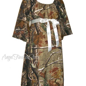 May include: A camouflage print dress with a white satin ribbon tied at the waist. The dress has a loose, flowing fit and is perfect for a casual occasion.