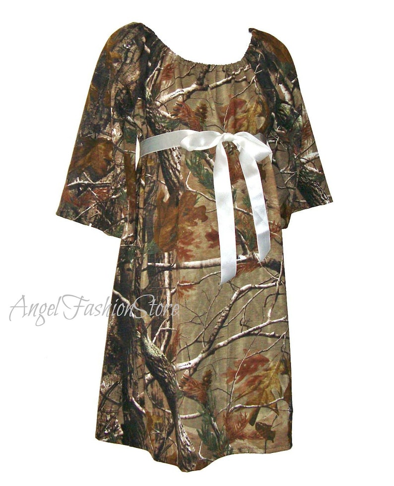 May include: A camouflage print dress with a white satin ribbon tied at the waist. The dress has a loose, flowing fit and is perfect for a casual occasion.