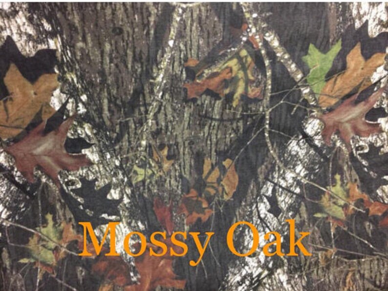 May include: A close-up of a camouflage fabric with a brown, green, and white pattern. The fabric has the words "Mossy Oak" printed on it.