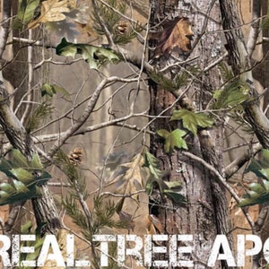 May include: A camouflage pattern with brown, green, and white colors. The pattern features branches, leaves, and tree trunks. The text "REAL TREE APG" is printed at the bottom of the image.