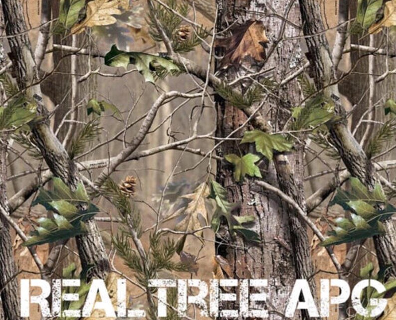 May include: A camouflage pattern with brown, green, and white colors. The pattern features branches, leaves, and tree trunks. The text "REAL TREE APG" is printed at the bottom of the image.