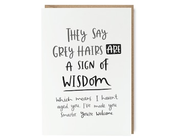 May include: A white greeting card with black handwritten text that reads "THEY SAY GREY HAIRS ARE A SIGN OF WISDOM" and "Which means I haven't aged you. I've made you Smarter. You're welcome."
