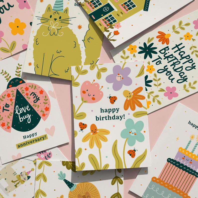 May include: A collection of colorful greeting cards with floral and animal illustrations. Designs include a cat in a party hat, a ladybug with text, and cards that say "Happy Birthday" and "Happy Anniversary!" on a pink background.