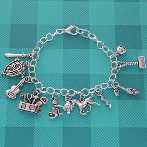 May include: A silver charm bracelet with a variety of charms, including a rose, a toolbox, a guitar, a monkey, a mushroom, a horse, a lightning bolt, a smiley face, and a hammer.