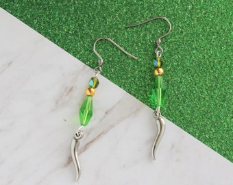 Puede incluir: Un par de pendientes de plata con cuentas verdes y doradas con forma de chiles.