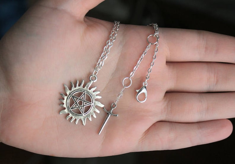 K&ouml;nnte beinhalten: Silberne Halskette mit einem Pentagramm-Anh&auml;nger in einem Kreis und einem Schwertanh&auml;nger.