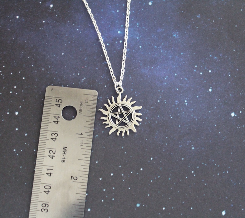 K&ouml;nnte beinhalten: Silberne Halskette mit einem Pentagramm-Anh&auml;nger in einem Sonnensymbol. Der Anh&auml;nger hat einen Durchmesser von etwa 2,5 cm.