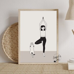May include: Black and white line art print of a woman doing a yoga pose with a cat standing on its hind legs beside her. The print is framed in a light wood frame and has the text "Sayali's Art" in the bottom right corner.