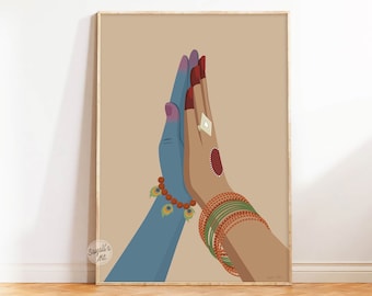 May include: Two hands in a prayer position, one hand is blue with a peacock feather bracelet, the other hand is brown with multiple bangles, the background is a light brown color.