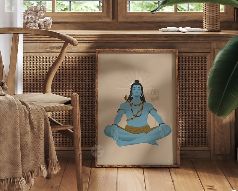 May include: A framed art print featuring a blue-skinned figure with dark hair, a crescent moon, and a snake around the neck, sitting in a meditative pose. The figure wears a gold cloth and holds a trident, set against a light tan background.