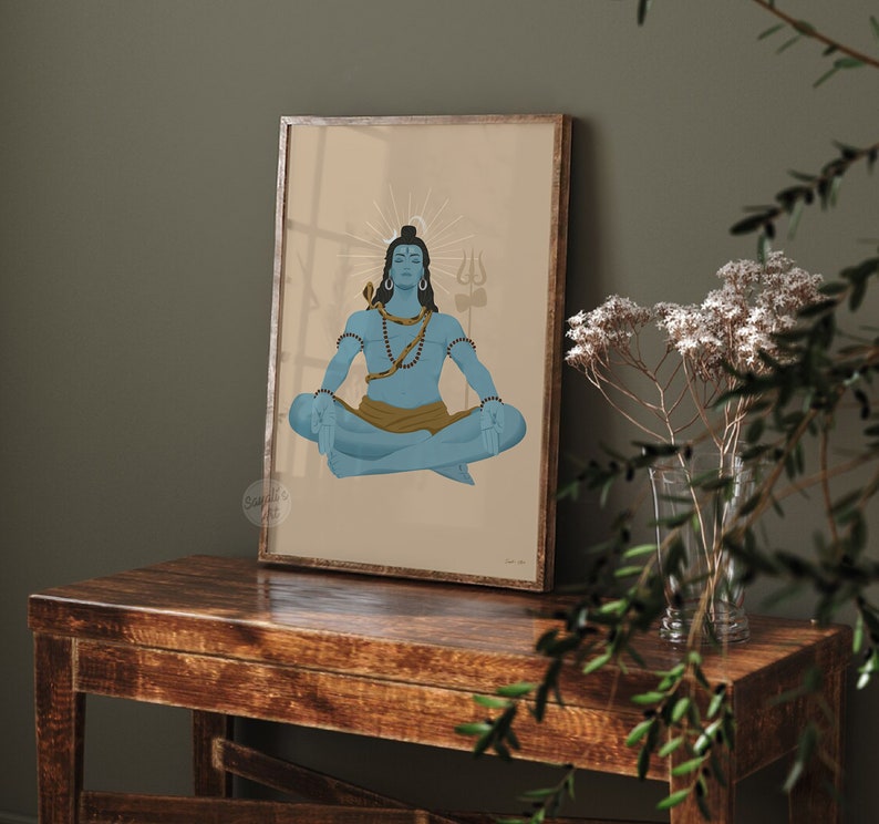 May include: A framed wall art print featuring a blue-skinned figure in a meditative lotus position. The figure wears a golden snake around the neck, a brown waist cloth, and has a trident symbol in the background with a light halo effect.