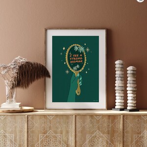artwork of a quote "i see a strong woman" is written on a mirror held by a woman hand, this artwork is in emerald green in color .it is a vertical poster