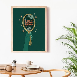 artwork of a quote "i see a strong woman" is written on a mirror held by a woman hand, this artwork is in emerald green in color .it is a vertical poster