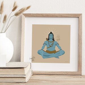 May include: A square framed print featuring a blue-skinned figure in a meditative lotus pose against a tan background. The figure wears a snake around the neck, beads, and a brown cloth, with a trident symbol and a circular halo behind the head.