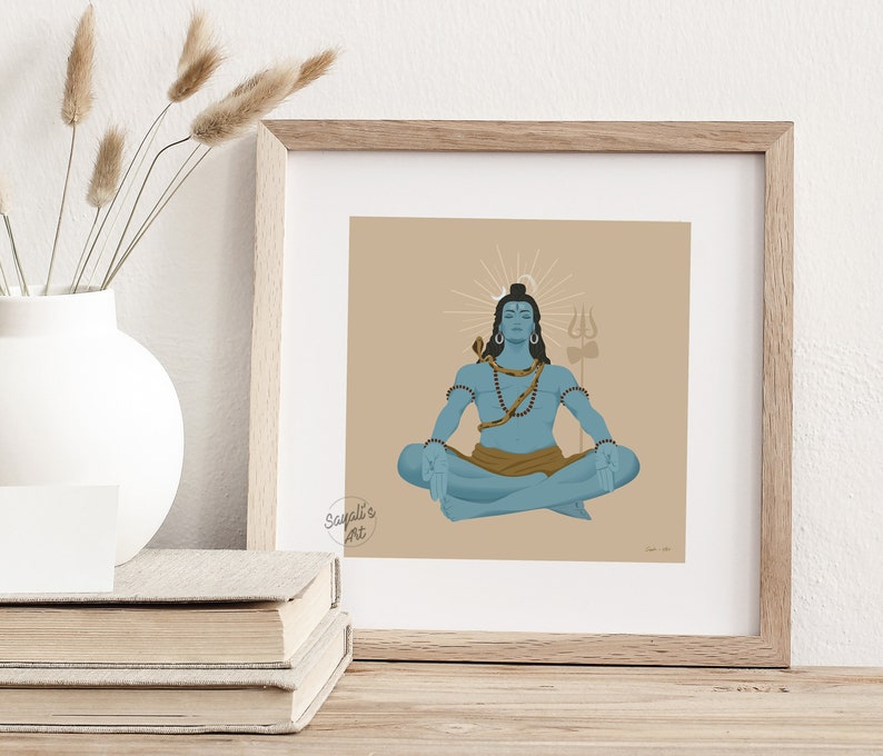 May include: A square framed print featuring a blue-skinned figure in a meditative lotus pose against a tan background. The figure wears a snake around the neck, beads, and a brown cloth, with a trident symbol and a circular halo behind the head.