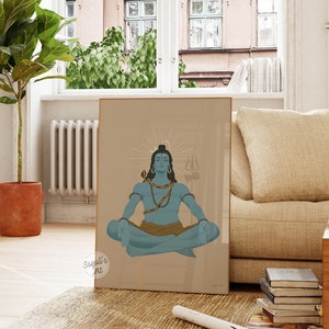 May include: A framed wall art print featuring a blue-skinned deity sitting in a meditative lotus position. The figure has a snake coiled around the neck, wears beads, and is positioned before a sunburst halo with a trident symbol in the background.