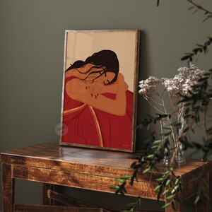Puede incluir: Una ilustraci&oacute;n digital de una mujer con el pelo largo y oscuro que lleva un sari rojo con ribetes dorados. Est&aacute; sentada con los brazos enroscados alrededor de s&iacute; misma, mirando hacia abajo.