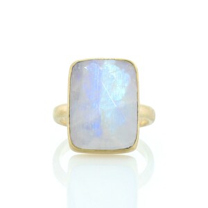May include: A gold ring with a large, rectangular, iridescent moonstone.