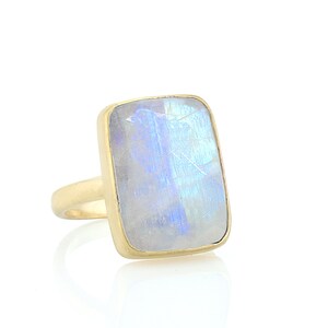 May include: A gold ring with a large, rectangular, iridescent moonstone.