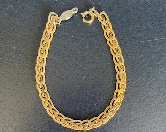 May include: A gold chain bracelet with a clasp. The chain is made of a woven design.