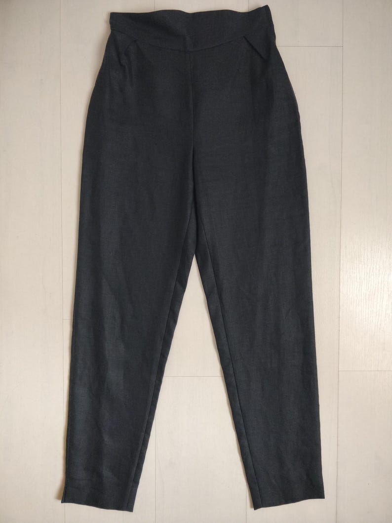 Puede incluir: Pantalones de cintura alta de color gris oscuro con una cinturilla ancha. Los pantalones tienen un dise&ntilde;o de pierna recta y est&aacute;n hechos de una tela suave y texturizada. Adecuados para uso informal o formal.