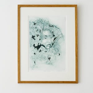 May include: A framed art print featuring a dark teal, sketch-style portrait of a face surrounded by swirling, leaf-like patterns. The artwork is encased in a light-toned wooden frame with a white mat border, presenting a detailed, monochromatic illustration.
