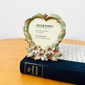 May include: A heart-shaped picture frame with a pale green leaf-patterned border, accented by small pink flowers and clear crystals. The insert text reads: PAST TIMES, Set of Two Leaf Heart, 3" x 3" Frames, For a photograph, 3" x 3" (7.7cm x 7.7cm).