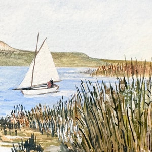Puede incluir: Una pintura de acuarela de un velero en un lago con altas ca&ntilde;as verdes en primer plano. El velero tiene una vela blanca y navega lejos del espectador. El lago es de color azul claro y el cielo es de color gris claro.