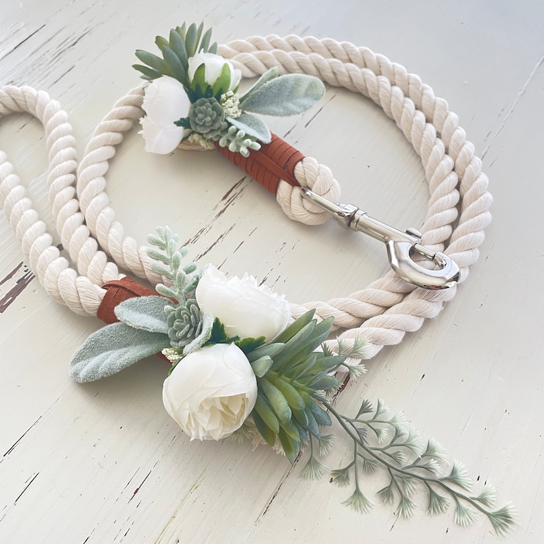 May include: White cotton rope leash with a silver clasp and two white flower and greenery embellishments.