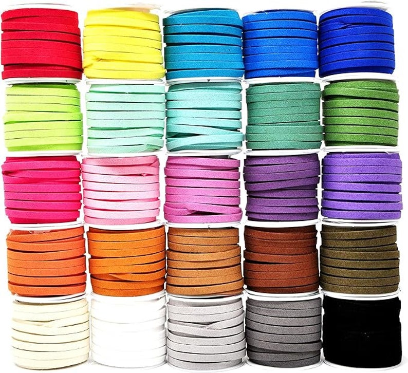 May include: A selection of colourful suede cords in a variety of shades, including red, yellow, blue, green, pink, orange, brown, and black. Each cord is neatly wound on a spool, offering a wide range of options for crafting and jewellery making.