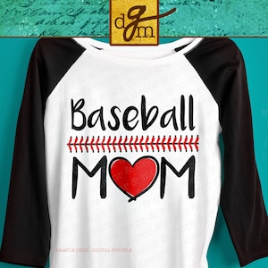 May include: A white baseball t-shirt with black sleeves. The shirt has a red heart with a baseball stitch design and the text "Baseball MOM" in black.