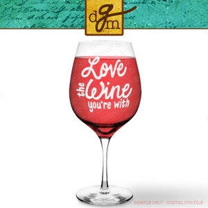 以下が含まれることがあります： 白い文字で「Love the wine you're with」と書かれた赤いワイングラス