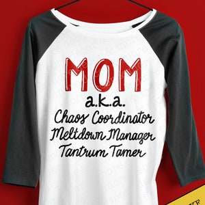 May include: A white baseball tee shirt with a black raglan sleeve design. The shirt has red text that reads "MOM a.k.a. Chaos Coordinator Meltdown Manager Tantrum Tamer".