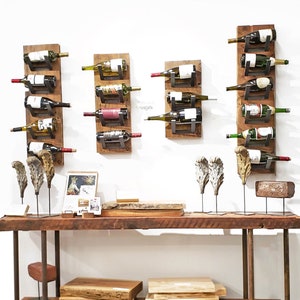 May include: A rustic wooden console table with two shelves, featuring a reclaimed wood top and metal legs. The table is decorated with two wooden wine bottle racks, each holding six bottles of wine. The table is also decorated with two decorative metal sculptures and a wooden sign.