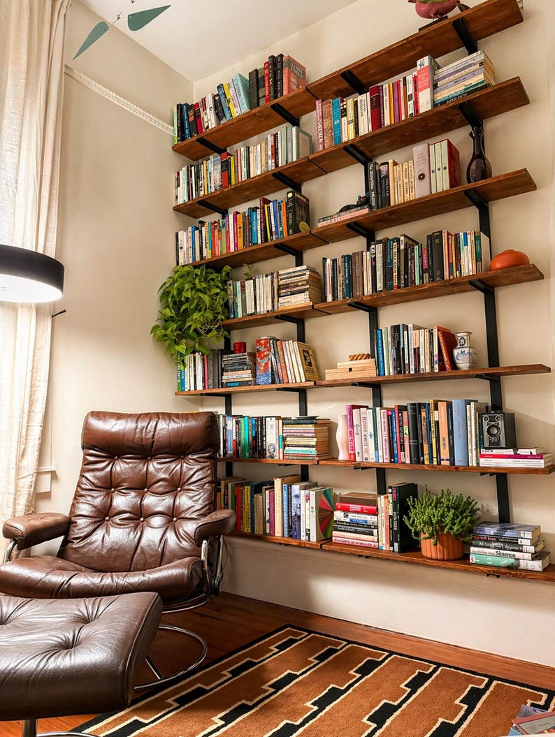 A home library featuring large wall-mounted bookshelves made from solid hardwood and solid steel brackets filled with books of various sizes and colors.