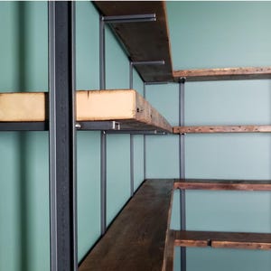 Solid steel shelf brackets with reclaimed wood floating bookshelf. Corner shelving unit