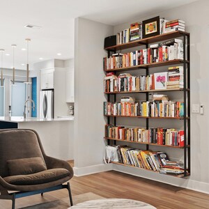 Modern industrial wall mounted bookcase. 6-tier shelving unit with black walnut wood and steel brackets filled with books in living room