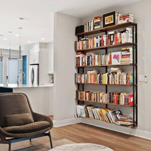 Floating Bookcase in a modern clean living room, providing clean and minimal storage solutions while maintaining a heavy duty support with black steel brackets and solid hardwood.