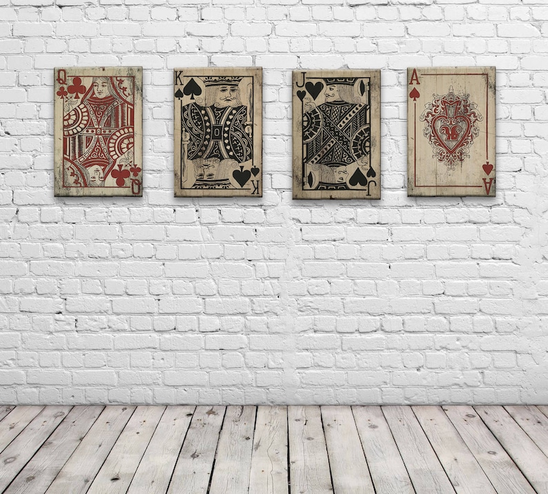 May include: Four vintage playing cards, Queen, King, Jack, and Ace of Spades, are displayed on a white brick wall. The cards are printed with a distressed, antique look.