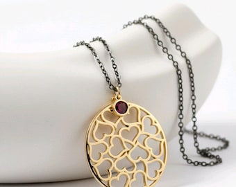 Collana lunga nera con ciondolo a forma di cuore grande.