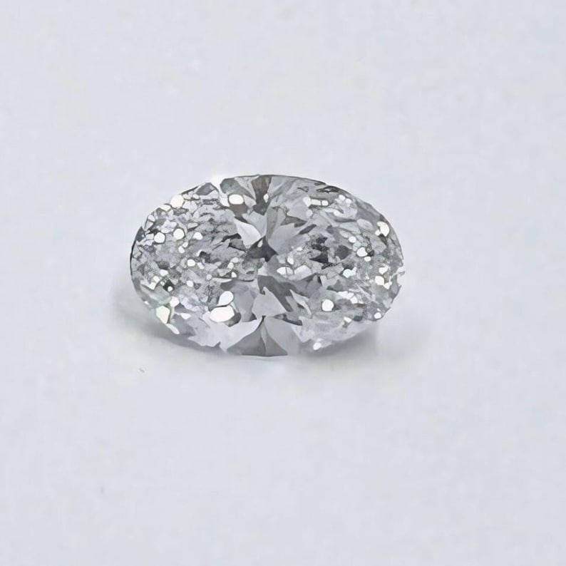 May include: A clear oval-shaped diamond gemstone with facets.