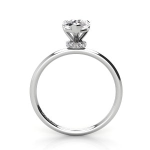 Puede incluir: Un anillo de compromiso de plata con una piedra central redonda y clara y una banda de diamantes m&aacute;s peque&ntilde;os alrededor de la base del engaste.