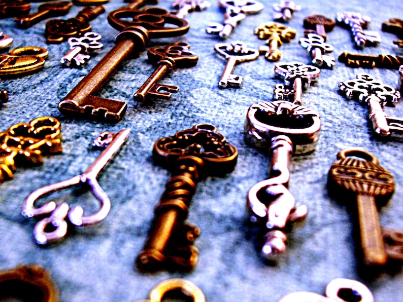 May include: A collection of antique keys in various styles and finishes, including silver, gold, and brass. Some keys have intricate designs and ornate details.