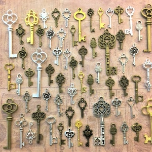 May include: A selection of vintage-style keys in different sizes and designs. The keys are in gold, silver, and bronze tones, with intricate details. The keys are displayed on a brown surface with printed text.